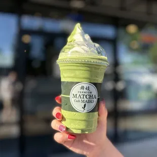 a hand holding a matcha cup