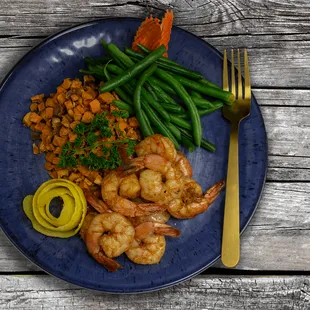 a plate of shrimp, green beans, and carrots