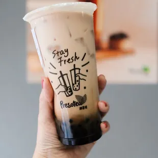 a hand holding a cup of iced coffee