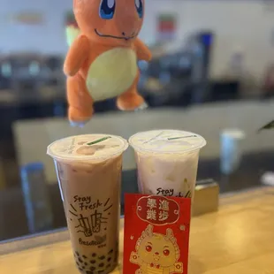 two cups of bubble tea and a pokemon plush toy