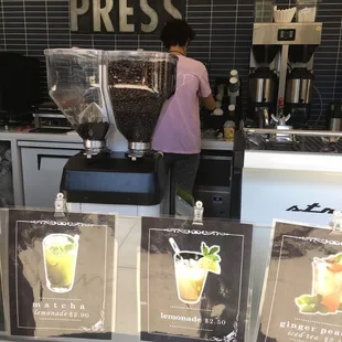 a woman preparing drinks in a coffee shop