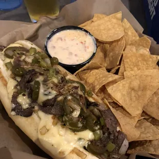 Prime rib philly with jalapeños and chips and queso.