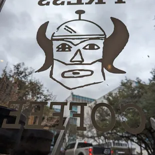 a coffee shop window with a drawing of a man's face