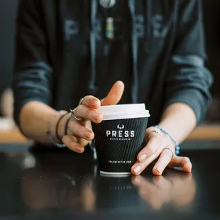 a person holding a cup of coffee