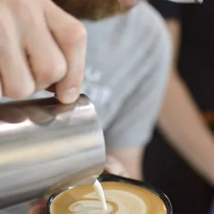 a man pouring milk into a cup