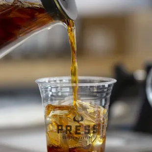 a cold beverage being poured into a glass