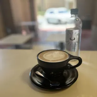 a cup of cappuccino and a bottle of water