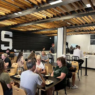 a large group of people sitting at tables in a coffee shop