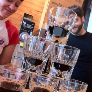 a man and a woman standing behind a table with glasses of wine