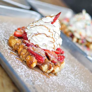The House with fresh cut strawberries, whipped cream, cookie butter, and Nutella