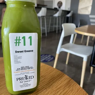 a bottle of green juice on a table