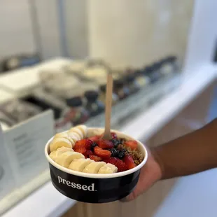 a person holding a bowl of fruit