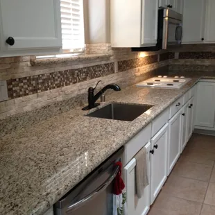 Giallo Ornamental Granite Countertops with Granite and Tile Backsplash.