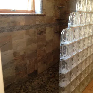 Custom Shower with Granite Shelves, Mosaic Pebble Floor, and Glass Block Wall.