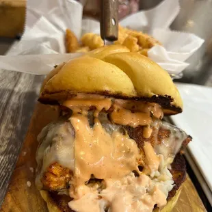 a chicken sandwich on a wooden cutting board