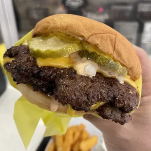 a hand holding a hamburger