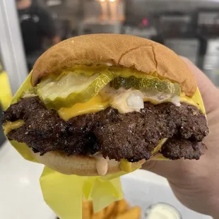 a hand holding a hamburger