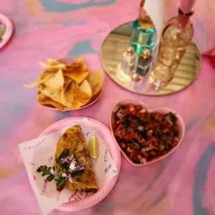 a pink table with plates of food