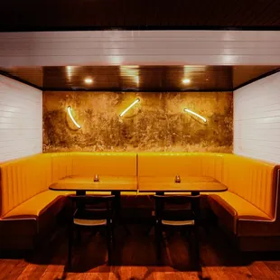 a corner booth with a table and chairs