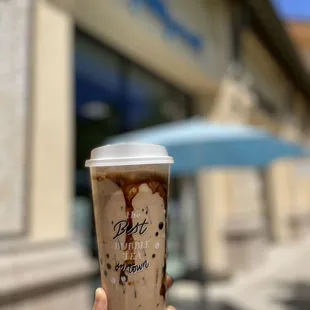 a hand holding a cup of iced coffee