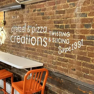 a brick wall and orange chairs