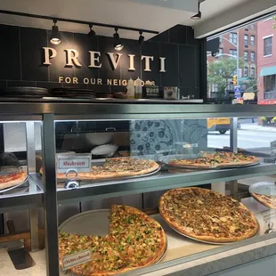 a variety of pizzas on display