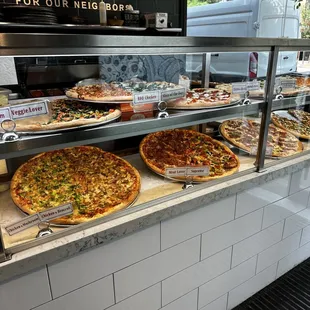 a variety of pizzas on display
