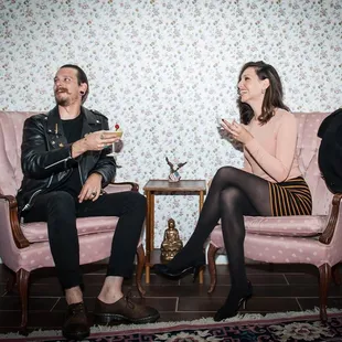 a man and a woman sitting on pink chairs