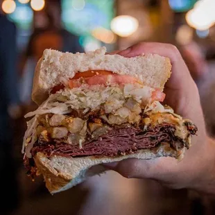 a hand holding a sandwich