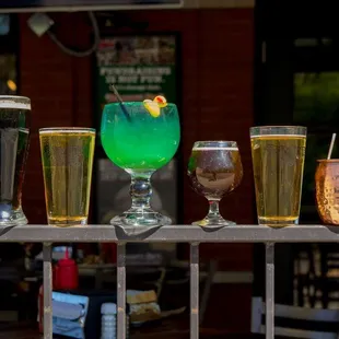 a row of beer glasses with different drinks