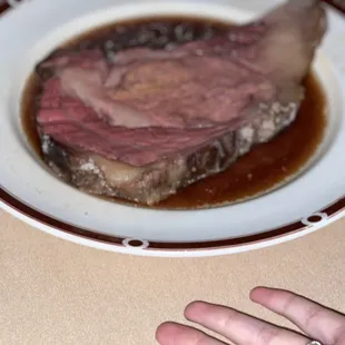 a person's hand reaching for a piece of meat