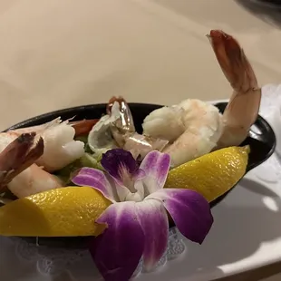 a plate of shrimp, shrimp, and lemon wedges