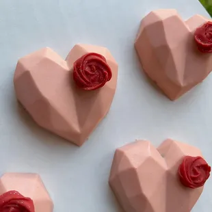 four heart shaped chocolates on a plate
