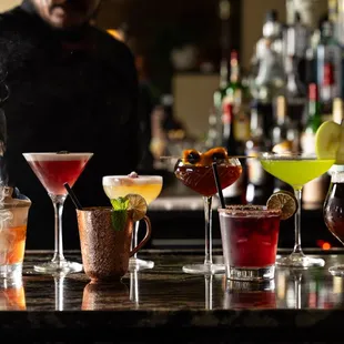A bartender makes several cocktails for a party