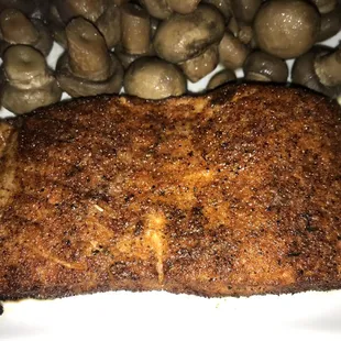 a piece of meat and mushrooms on a plate