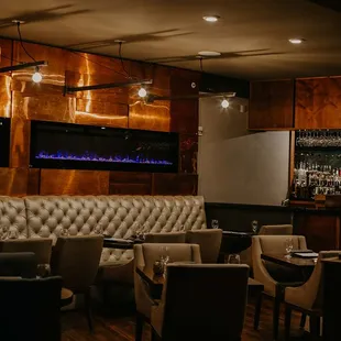 a dimly lit bar with leather seating