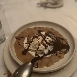 a plate of food with ice cream and chocolate sauce