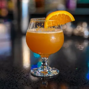 a glass of orange juice on a bar