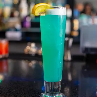 a blue drink with a slice of lemon on the rim