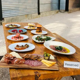 a wooden table with plates of food on it