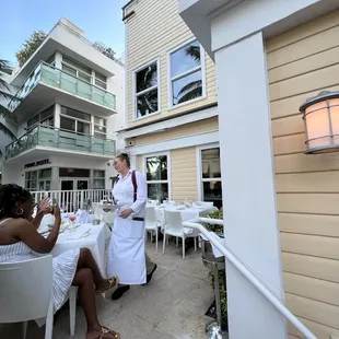 two women sitting at a table outside of a hotel