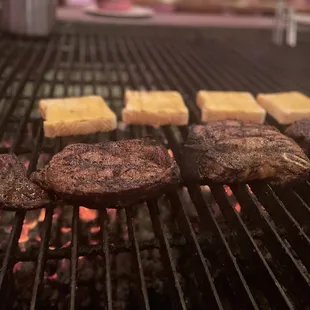 steaks cooking on a grill