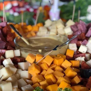 a platter of meat, cheese, and broccoli