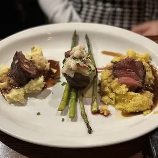 a plate of food with mashed potatoes and asparagus