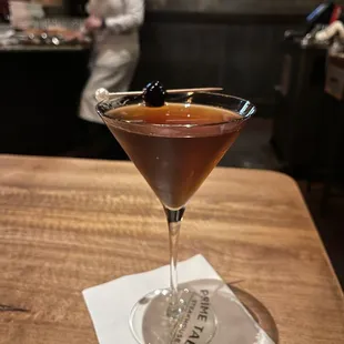 a cocktail in a martini glass on a napkin