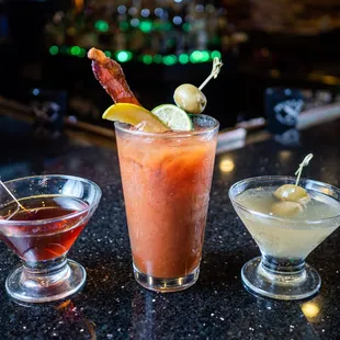 three cocktails on a bar counter