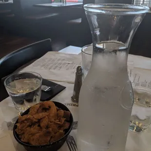 Freshly made house potato chips with a carafe of water.