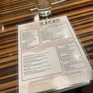 a menu and a drink on a table