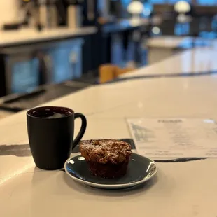 a cup of coffee and a muffin on a plate