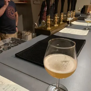 a glass of beer on a bar